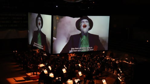 Photograph of Batman concert featuring on stage screens and orchestra